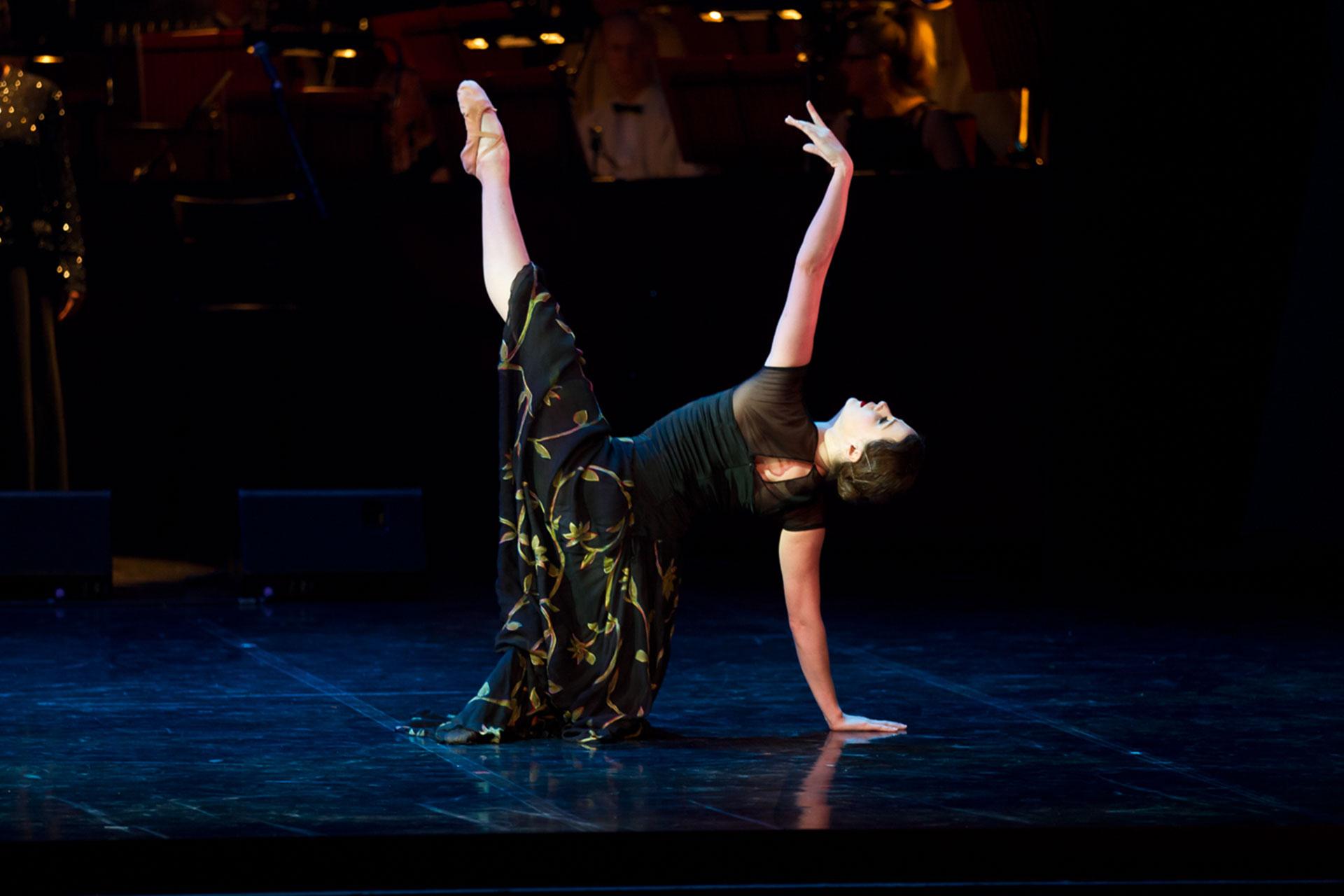 Geogina May reaches up with an arm and leg while the others hold her steady on the floor