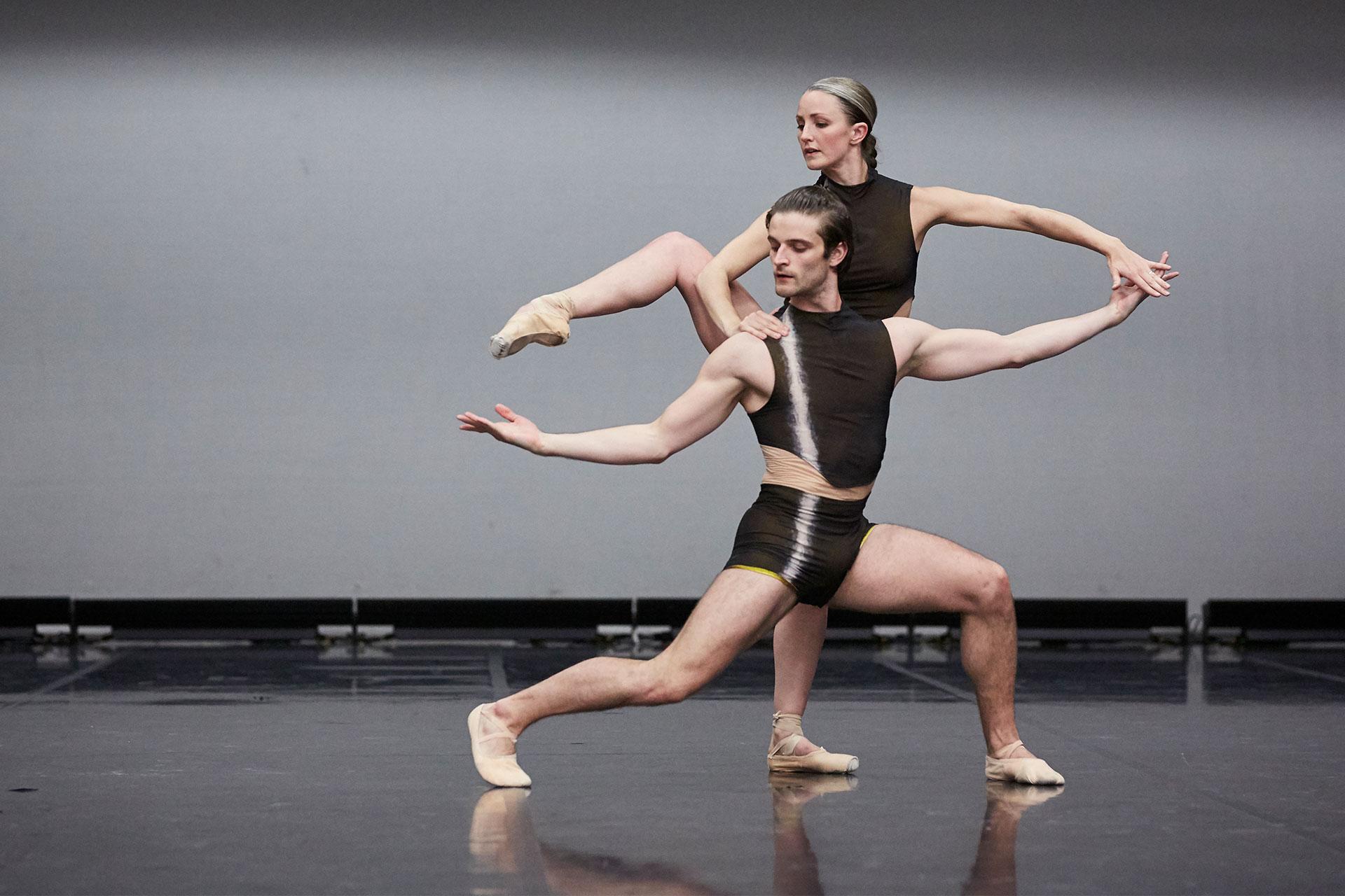 Nicola Gervasi stands low in front of Hannah Bateman as she raises a leg while keeping her foot pointed