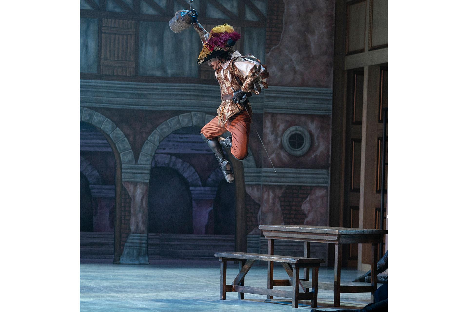 A drunken Porthos leaps of the tavern bench