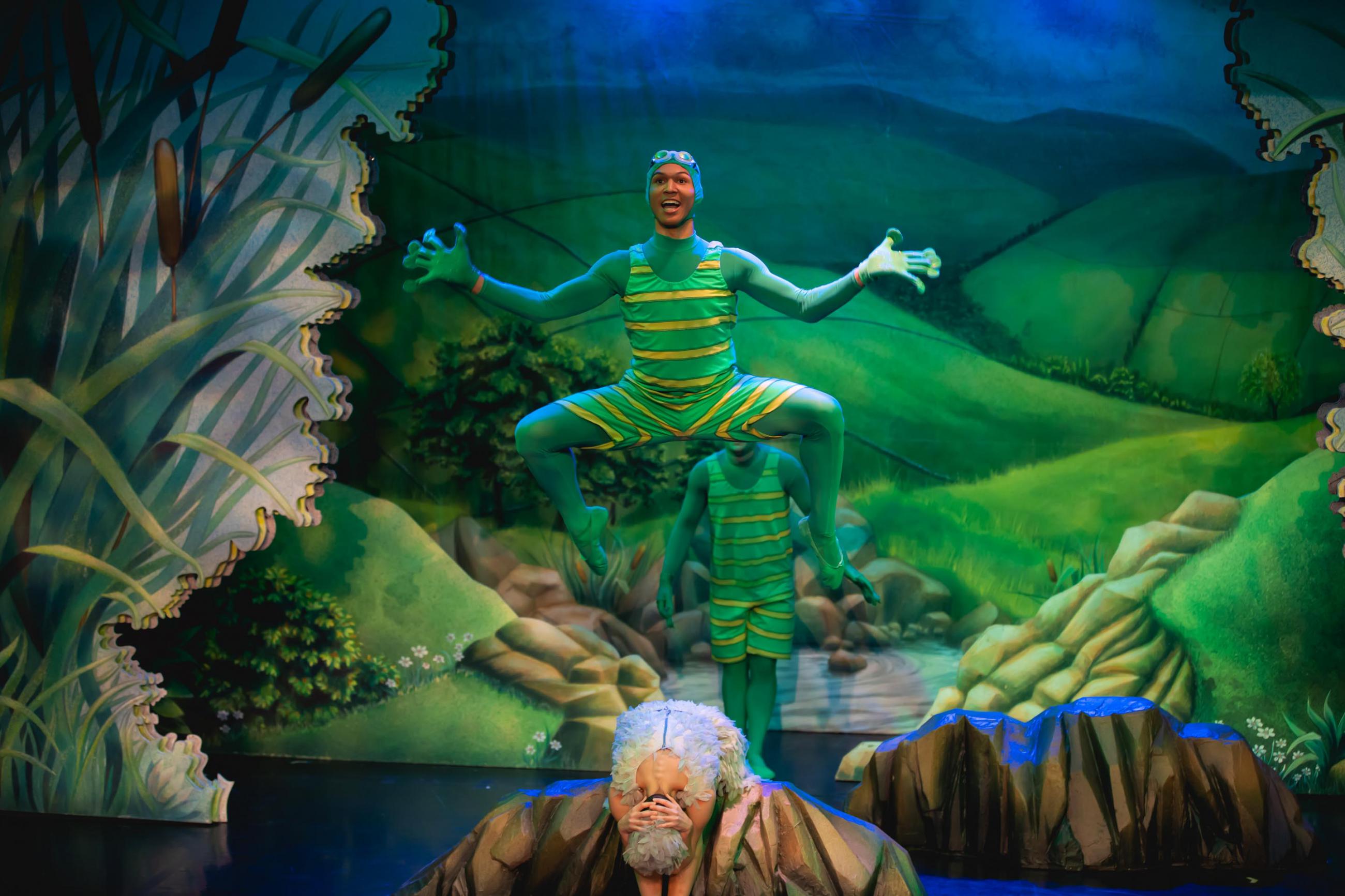 A dancer leap frogging over another