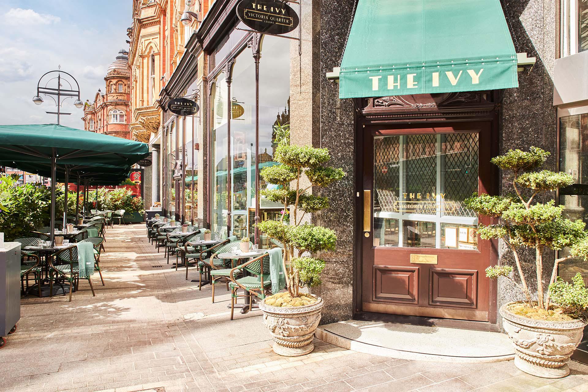 The door of the restaurant The Ivt shaded by a green awning in the bright sunshine