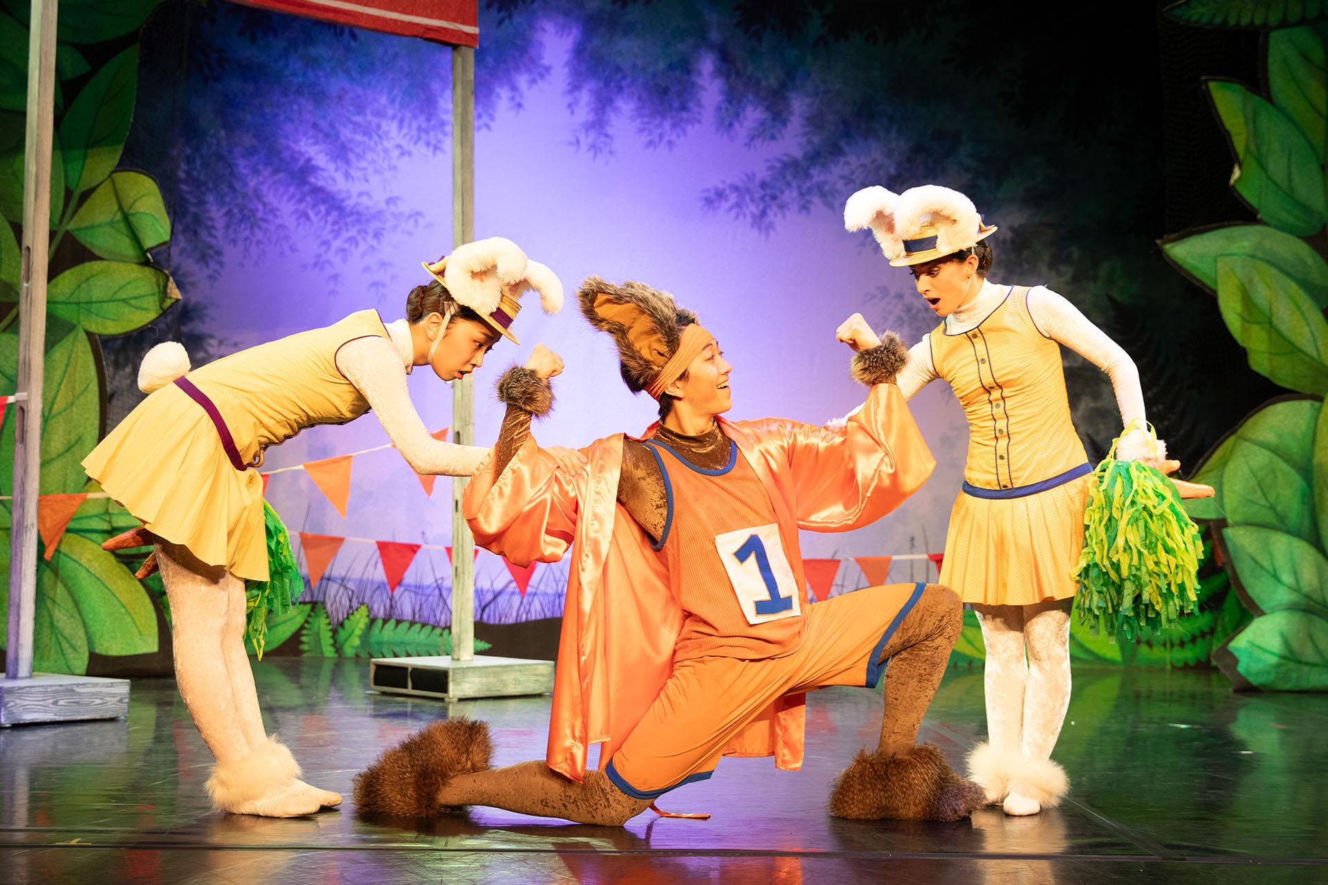 Three dancers in bunny costumes. Looks of excitement and joy