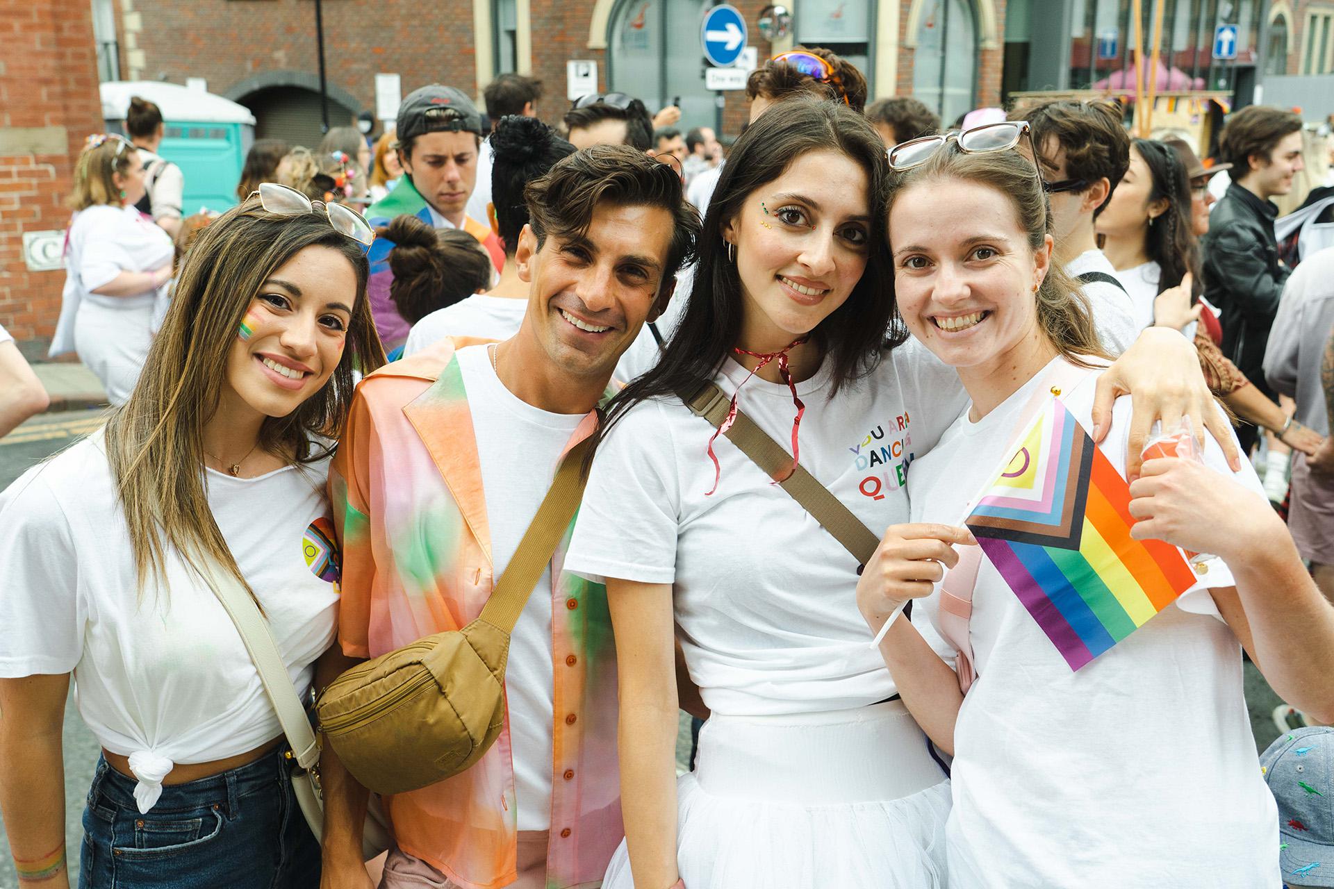 Dancers during the Pride parade in Leeds embracing each other and smiling broadly