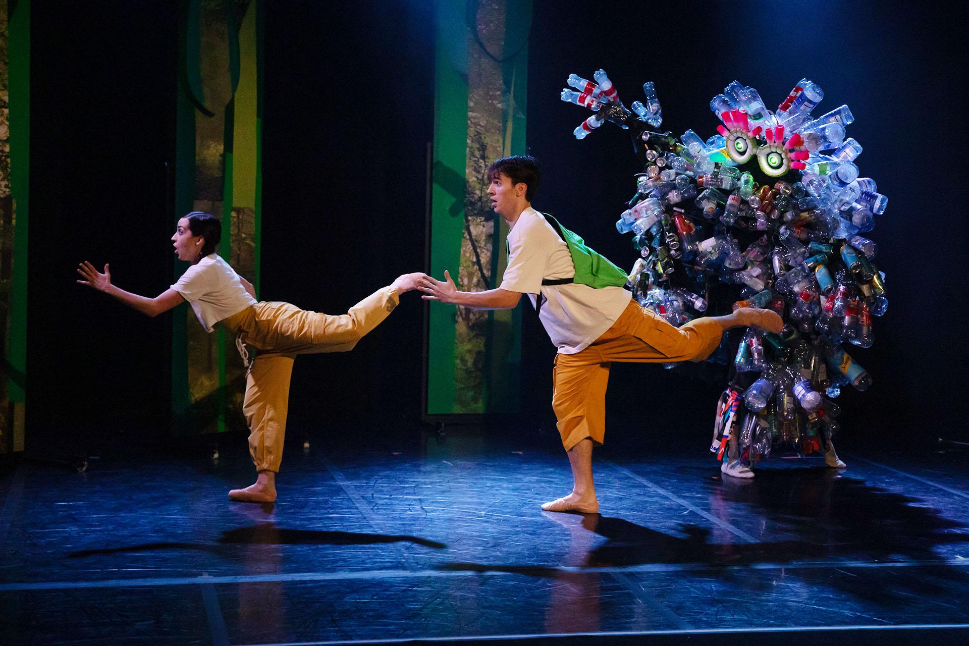 Hansel and Gretel being to run as the big Rubbish Monster approaches them, he is covered in plastic bottles and tin cans.