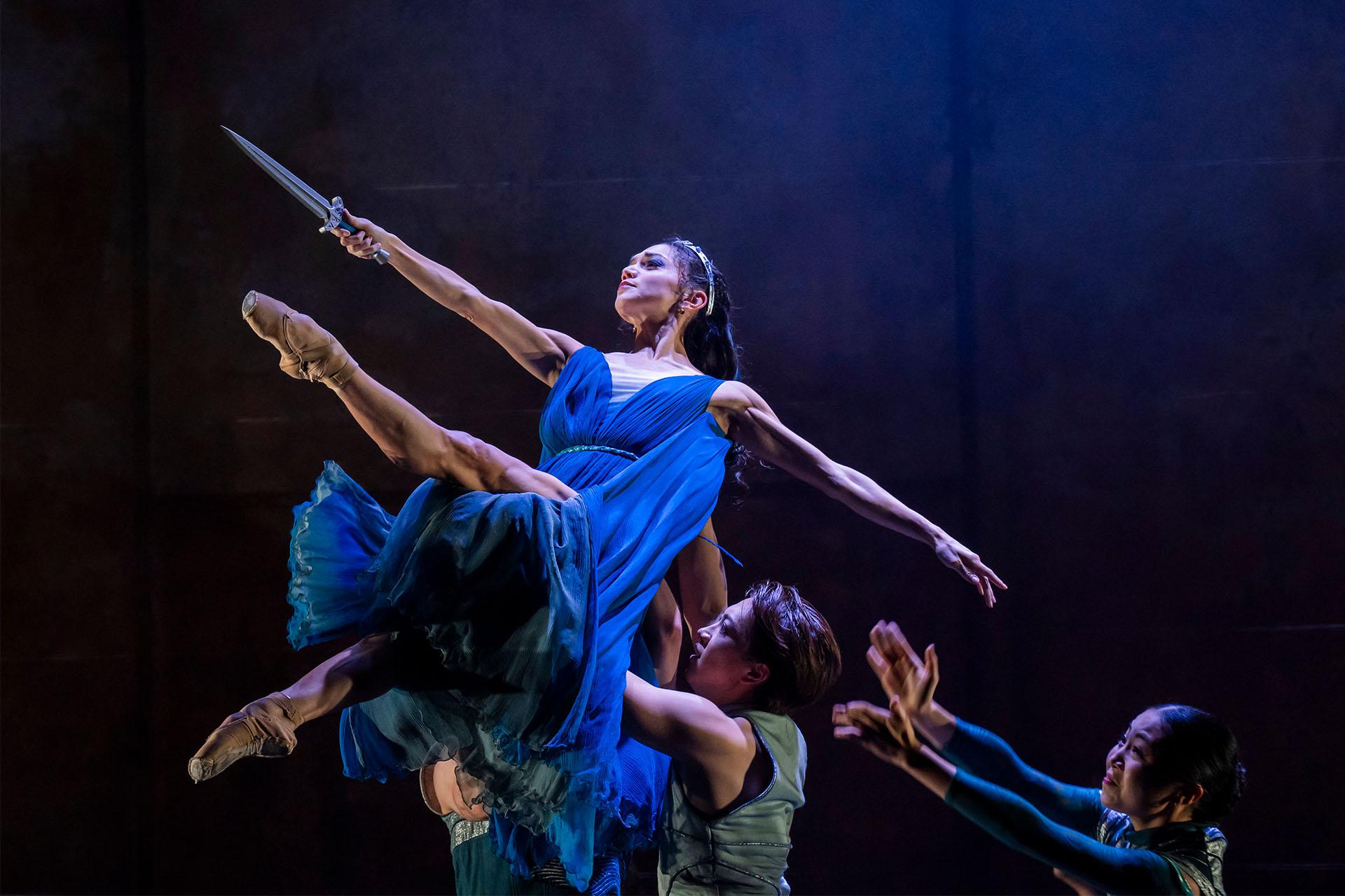 Dressed in blue, Ygraine is lifted, her dragger held straight before her