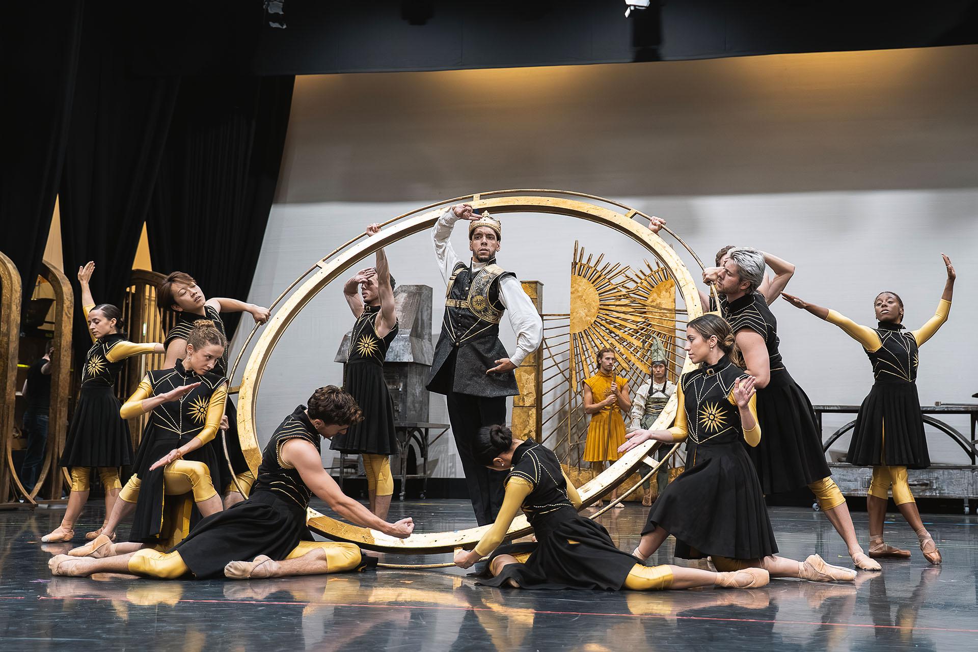 The king stands in a sacred circle, his subjects and army kneeling and standing around him