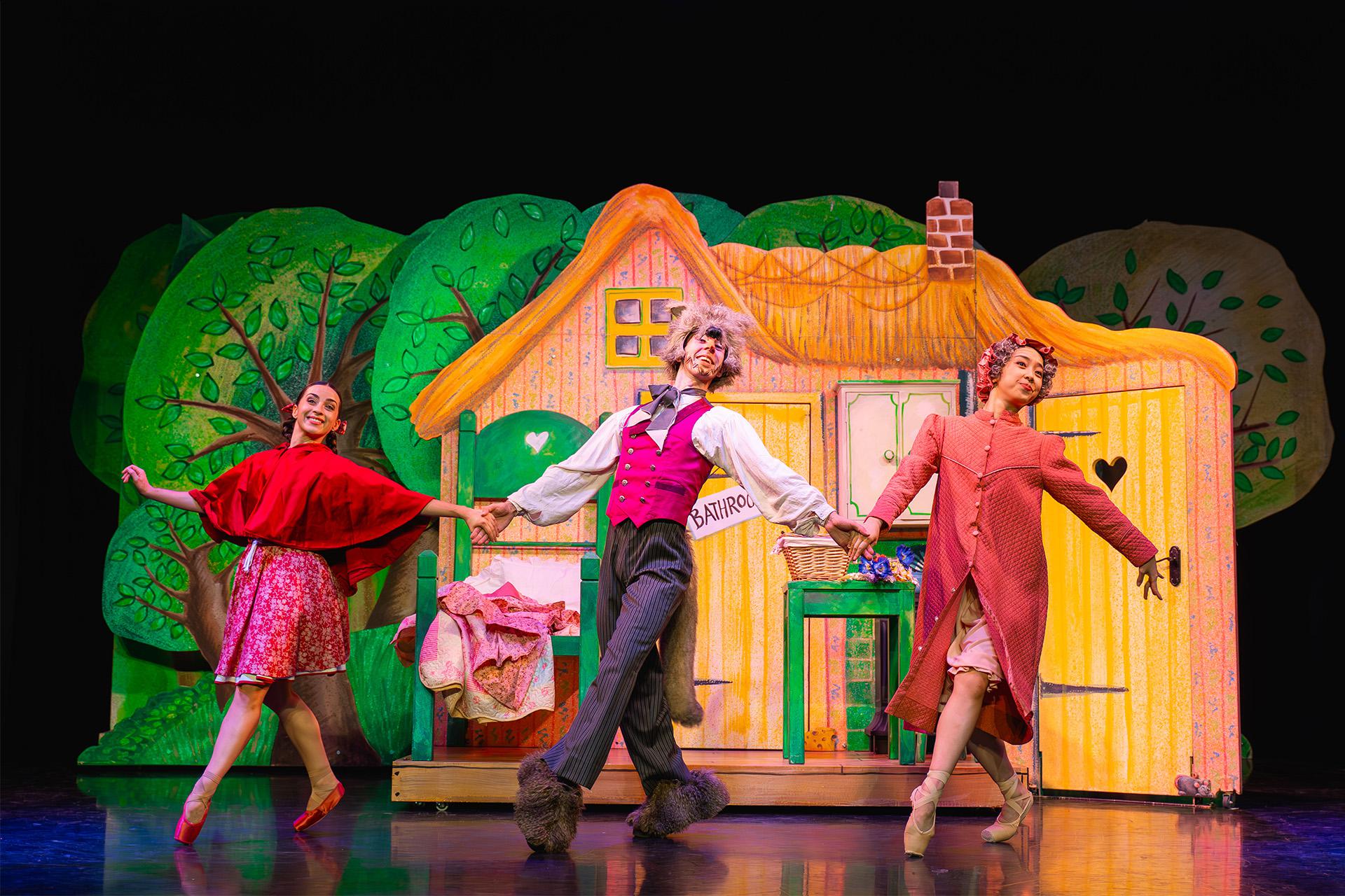 Little Red, her grand-mother and the wolf all dance together, happily and hand-in-hand