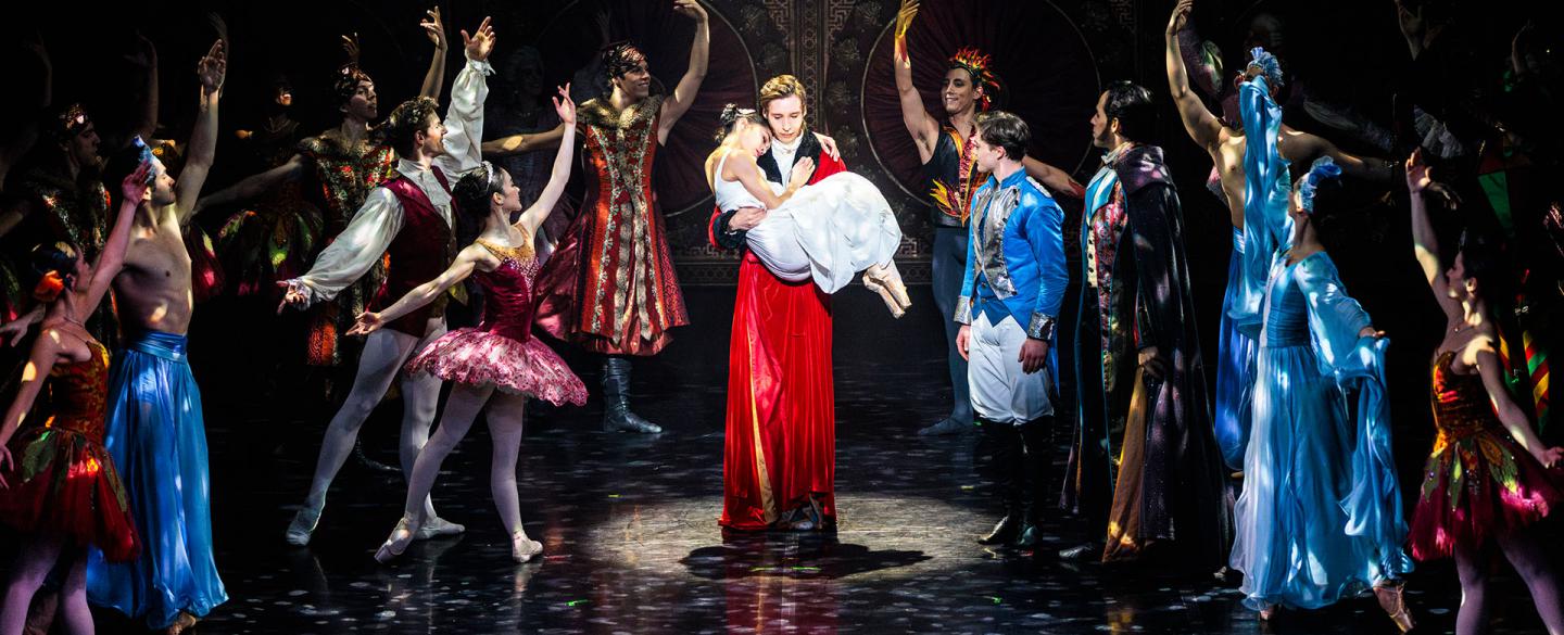 Clara's father carries her while she sleeps, the magical characters from her dreams look on