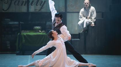 Scrooge watches on from a step in the background as a Young Scrooge dancers with Belle in the foreground.