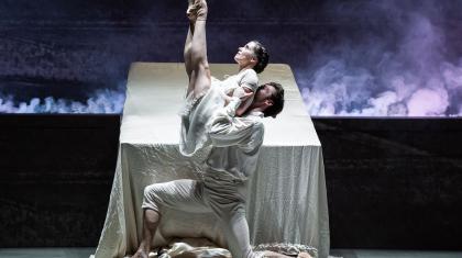 Dressed in their white night clothes and in front of their bad, Mr Rochester lifts Jane, her legs together and pointed at the sky