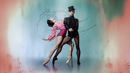 Wearing a black top hat and pointe shoes, the character of Gentleman Jack looks directly at the camera hands on a cane, a woman in pink hold onto her and leans back suggestively