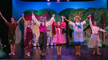 Six dancers in costume of Little Red Riding Hood taking a bow
